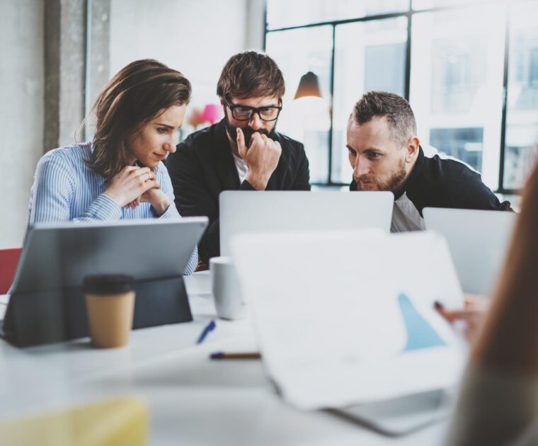 three people gathered around a laptop