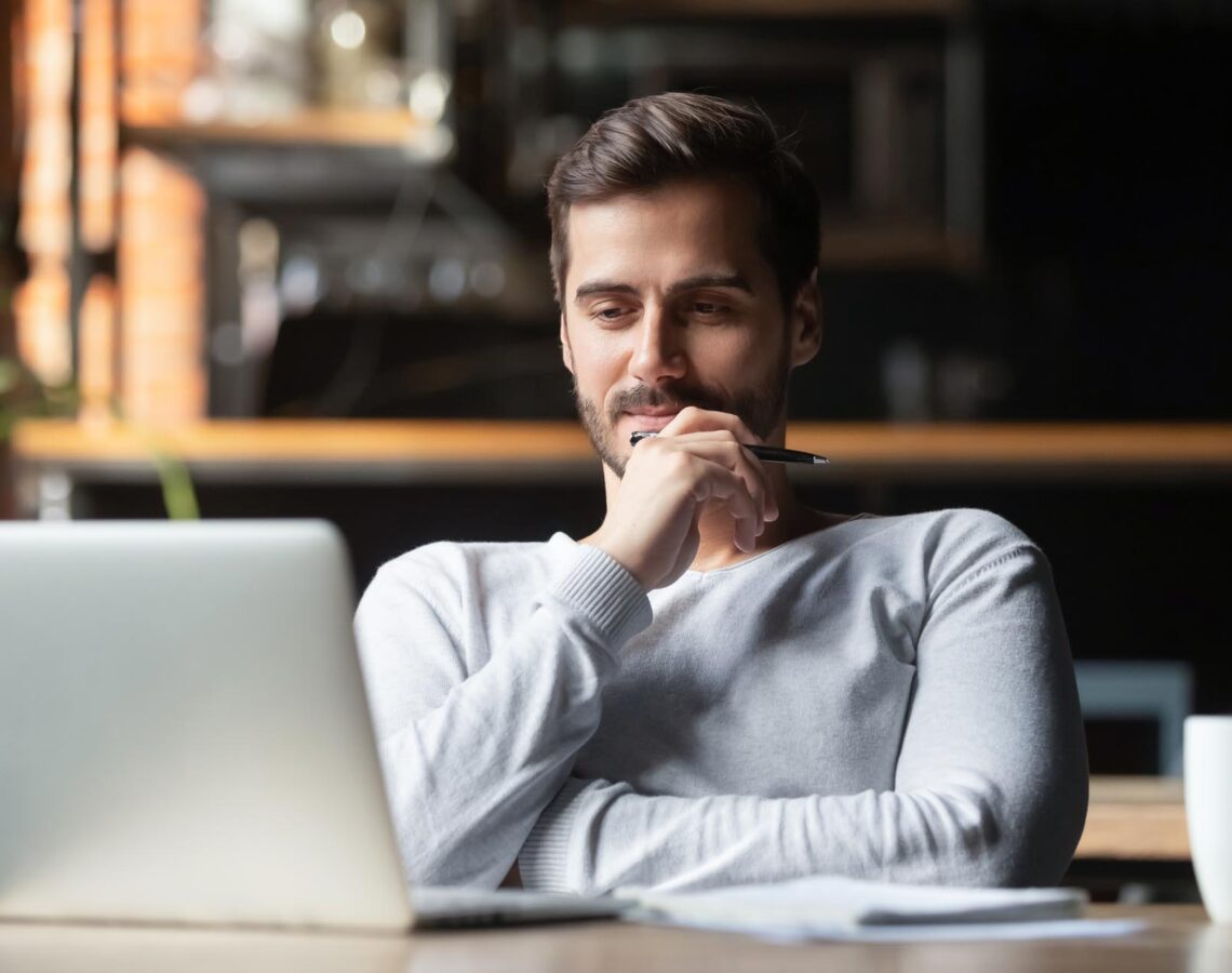 man thinking about work while looking at his laptop