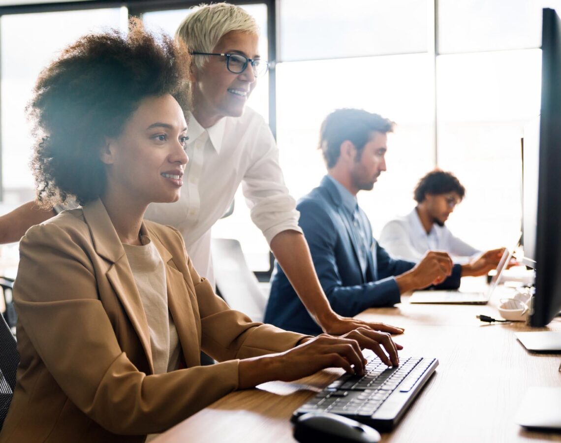 a woman working at a desktop computer in an office