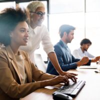 a woman working at a desktop computer in an office
