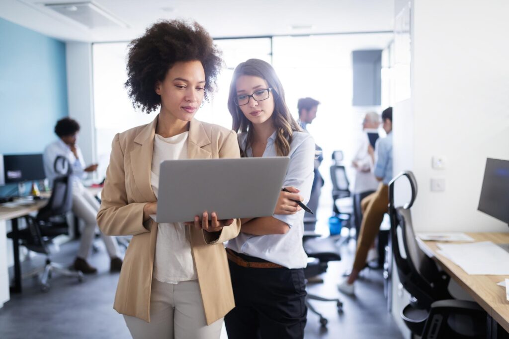 two female colleagues looking at information on a laptop