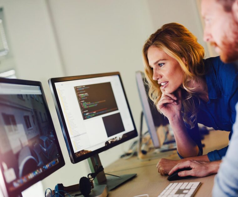 two workers looking at a laptop display