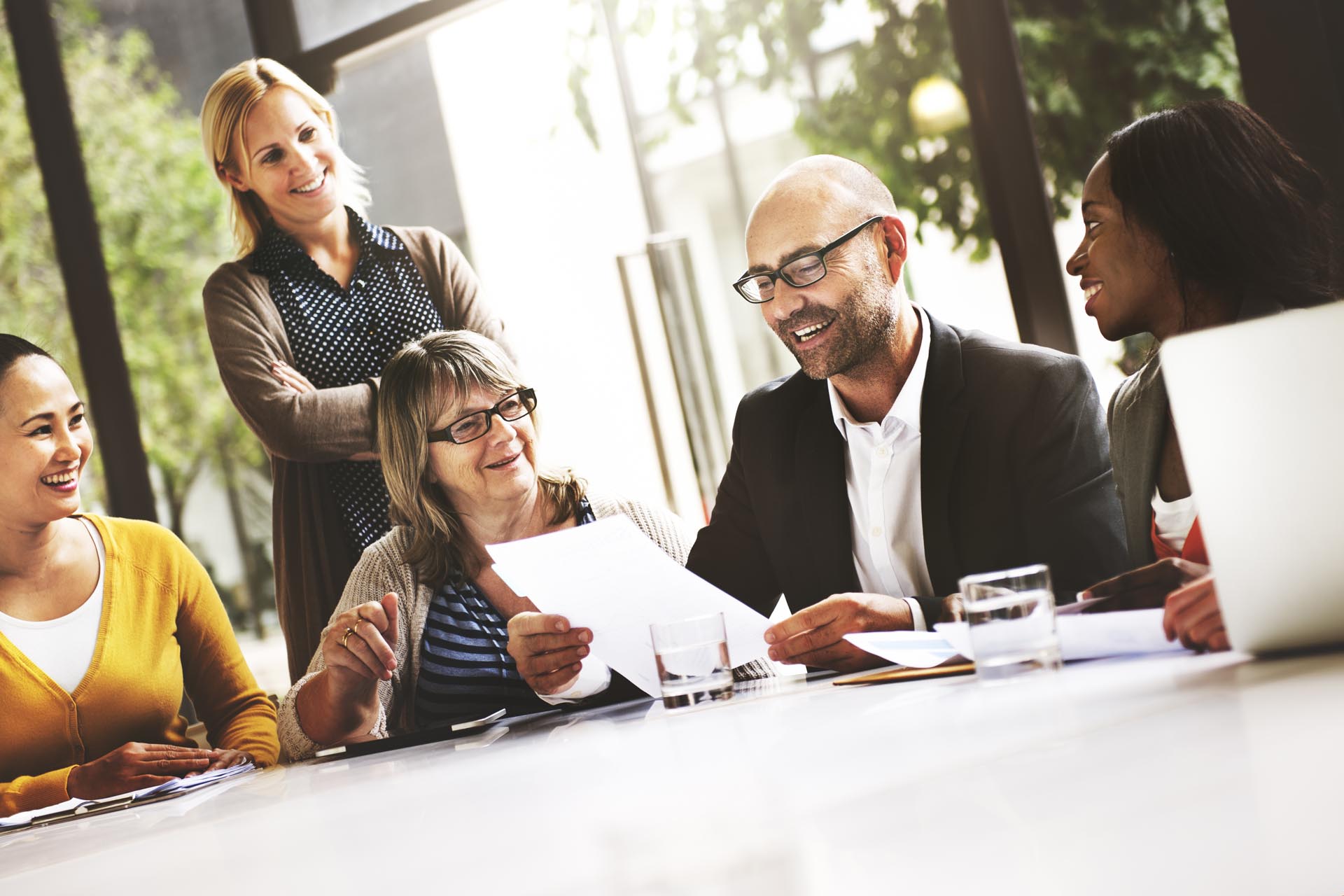 male colleague reading from a piece of paper surrounded by teammates