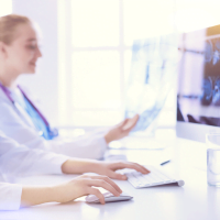 two doctors working at a mac computer