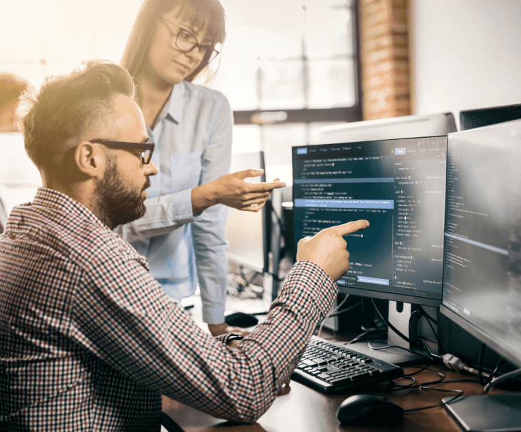 Two Workers At A Desktop Computer