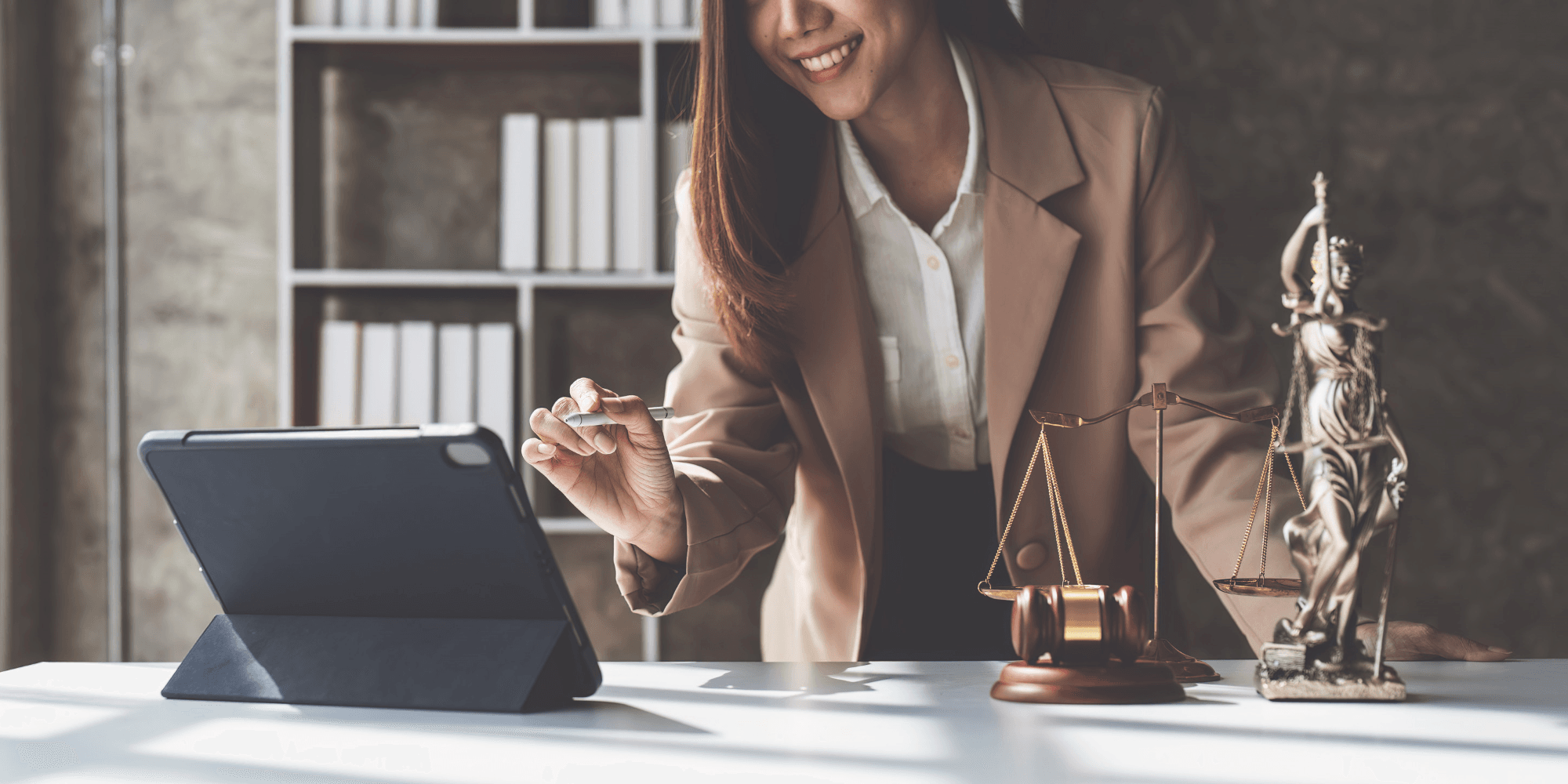 woman working on a tablet with legal items next to her