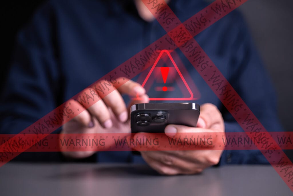 warning symbol on top of a smartphone